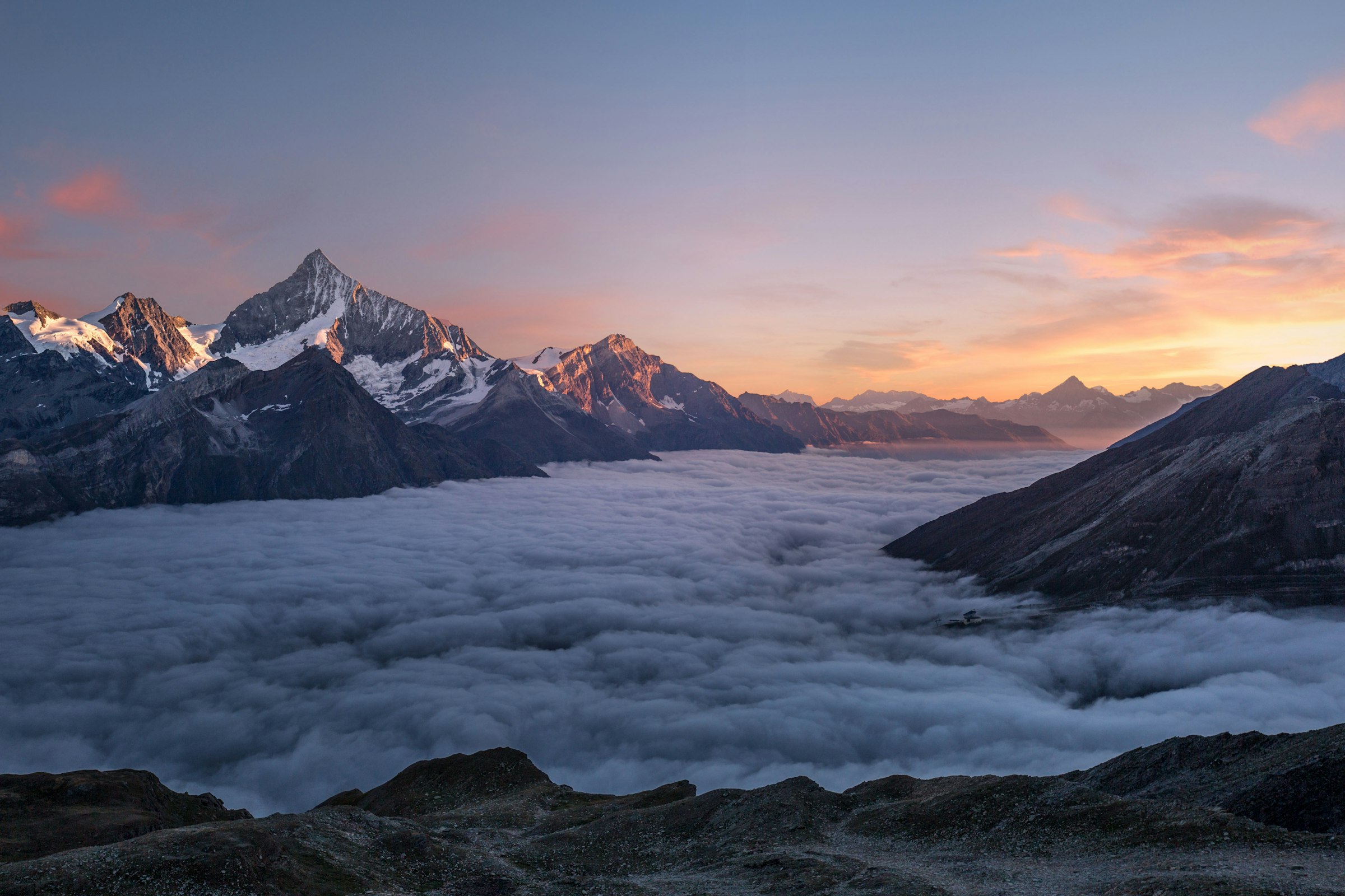 Alpine peaks at sunset rising over a sea of clouds
